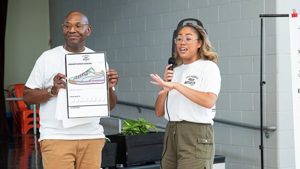 Dee Wells holding a sneaker design concept board beside Tausha, of Her Grails, at Celebrate H-Town Artists.